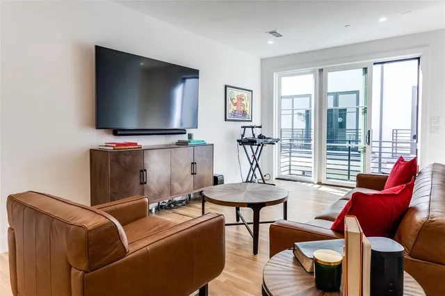 a living room with furniture a flat screen tv and a large window
