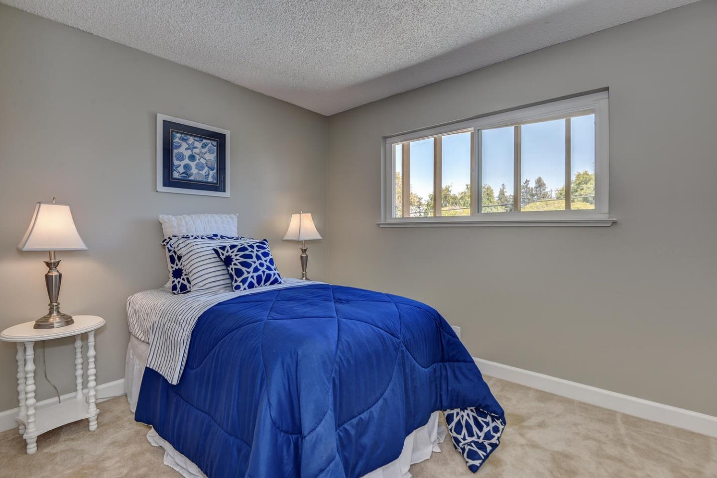 836 Pomeroy Avenue, Unit 70 Santa Clara, CA 95051 - Photo 13 of 17 a bed room with a bed and a painting on the wall