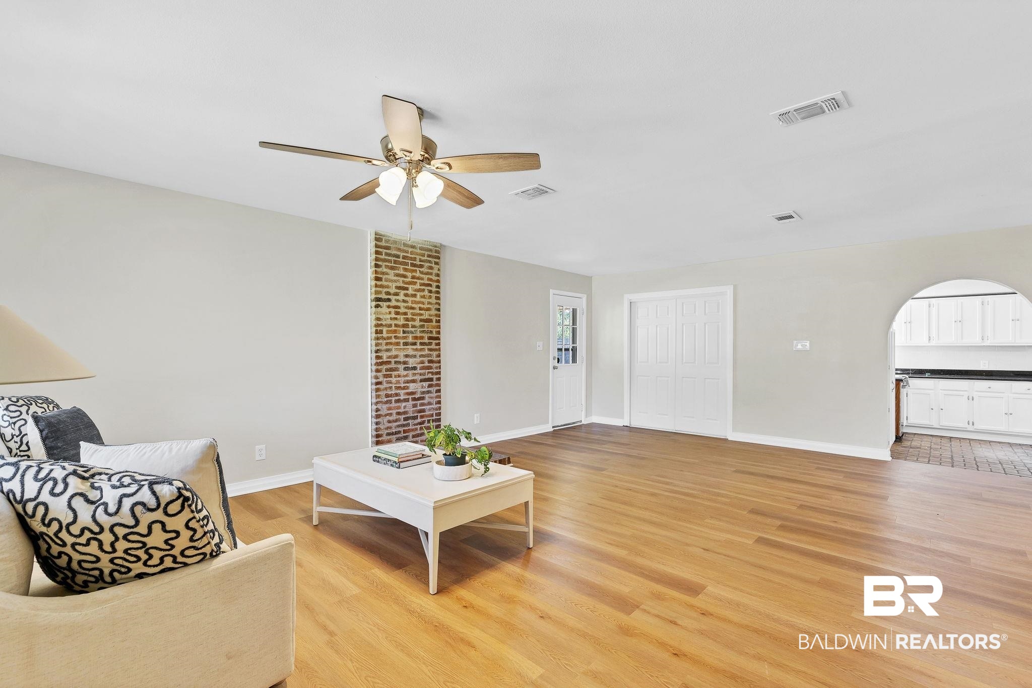 11964 Stroh Road Daphne, AL 36527 - Photo 12 of 58 Living area featuring baseboards, light wood-style flooring, a ceiling fan, visible vents, and arched walkways