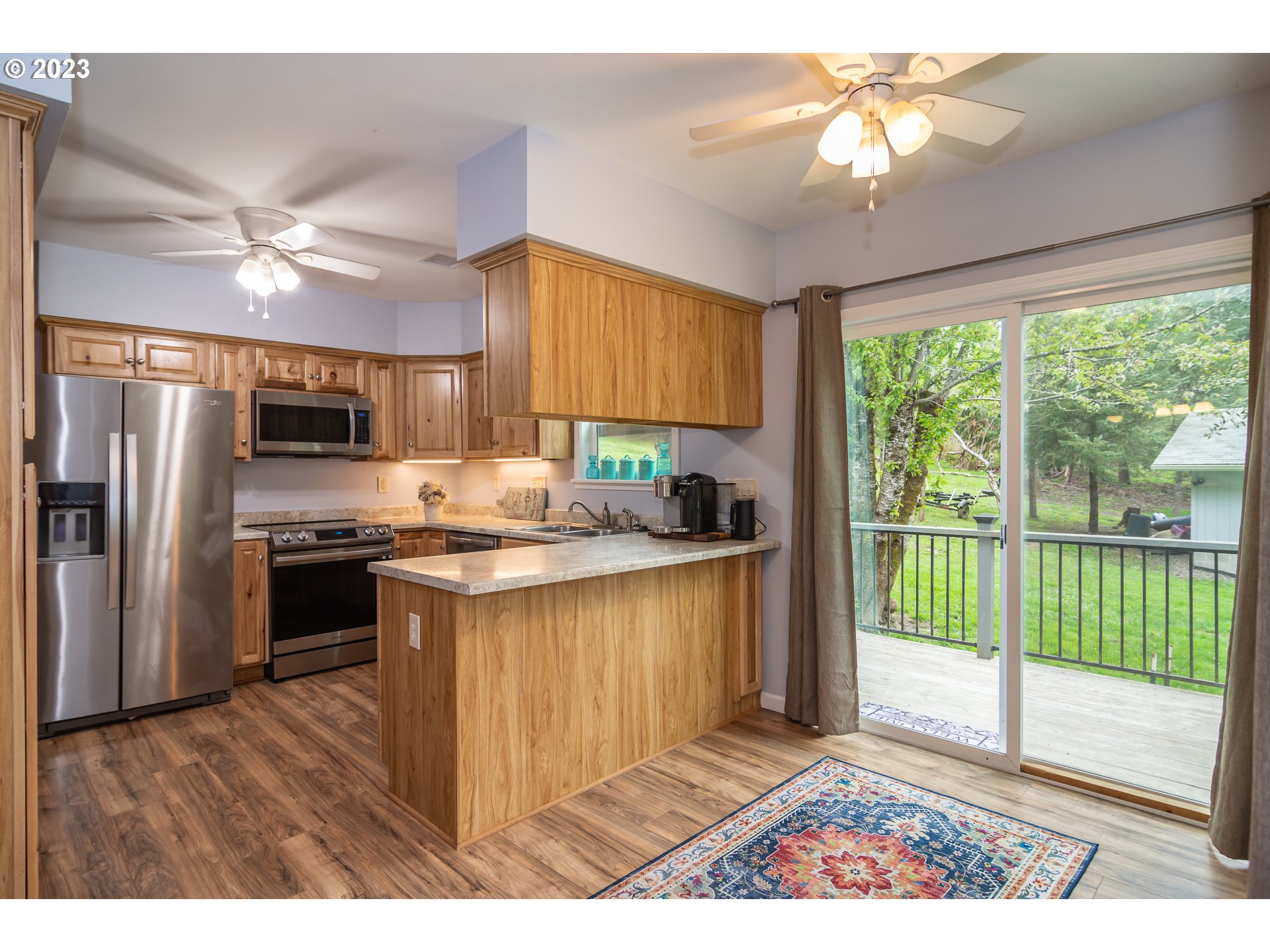 11533 Tyee Road Umpqua, OR 97486 - Photo 18 of 45 a kitchen with kitchen island granite countertop a stove a sink a refrigerator cabinets and wooden floor