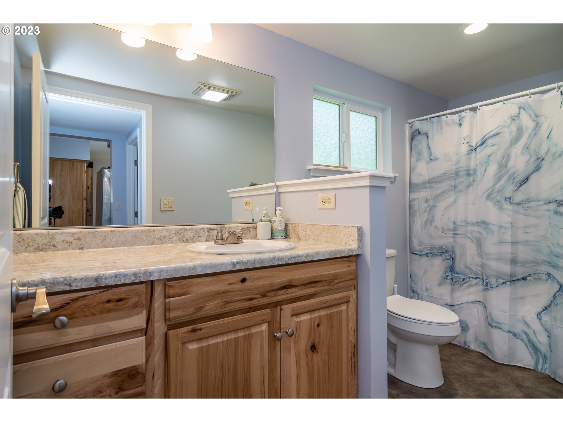 11533 Tyee Road Umpqua, OR 97486 - Photo 27 of 45 a bathroom with a granite countertop sink a toilet and a mirror