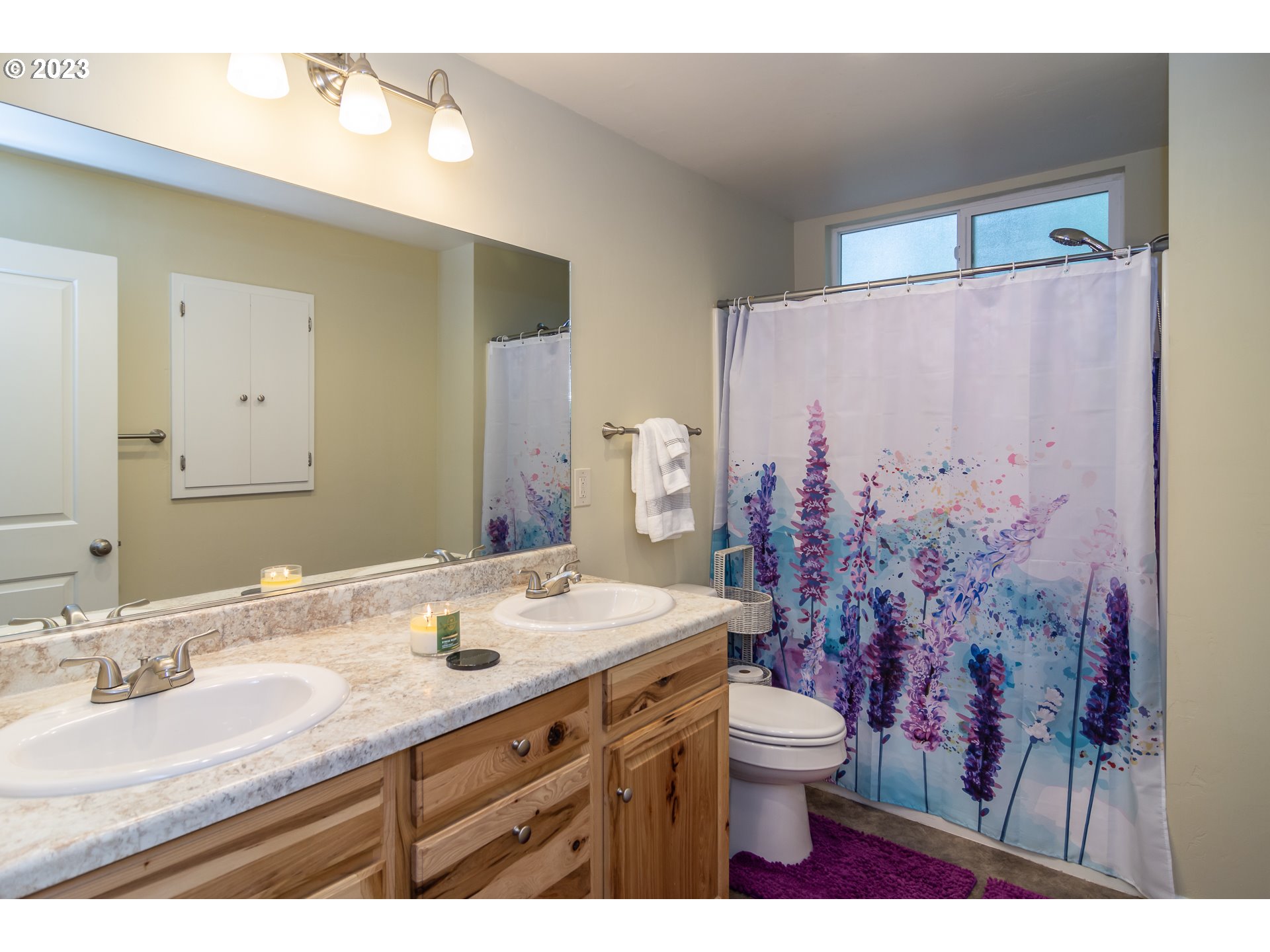 11533 Tyee Road Umpqua, OR 97486 - Photo 31 of 45 a bathroom with a granite countertop sink toilet a mirror and shower curtain