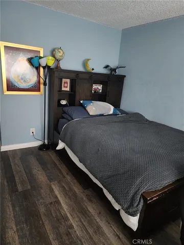 a bedroom with a bed and painting on the wall
