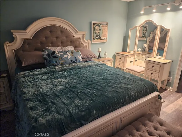 a bed sitting in a bedroom next to a window with pc on the table