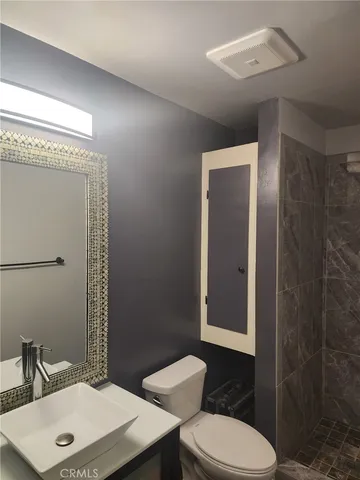 a bathroom with a toilet a sink and mirror