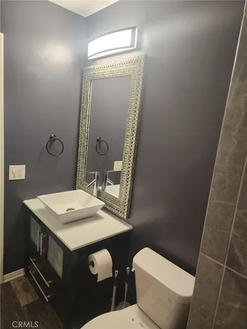 a bathroom with a sink a toilet a mirror and vanity