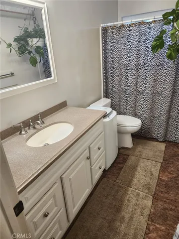 a bathroom with a granite countertop sink a large mirror and a toilet