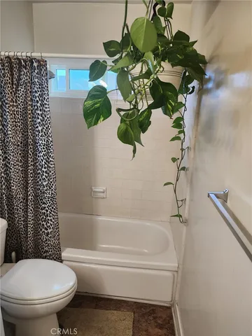 a white toilet sitting next to a bath tub
