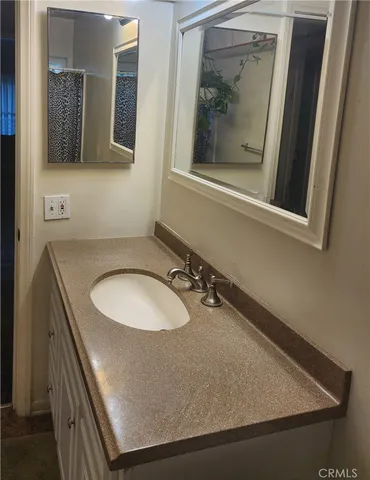 a bathroom with a granite countertop sink and mirror