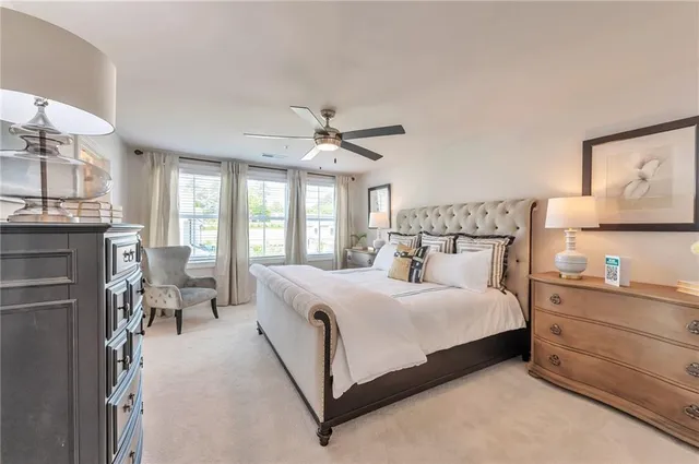 a bedroom with a large bed a flat tv screen and a dresser