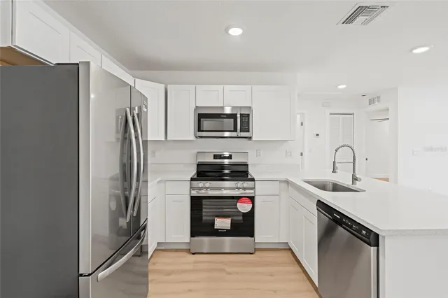 a kitchen with stainless steel appliances granite countertop a stove a refrigerator and a sink
