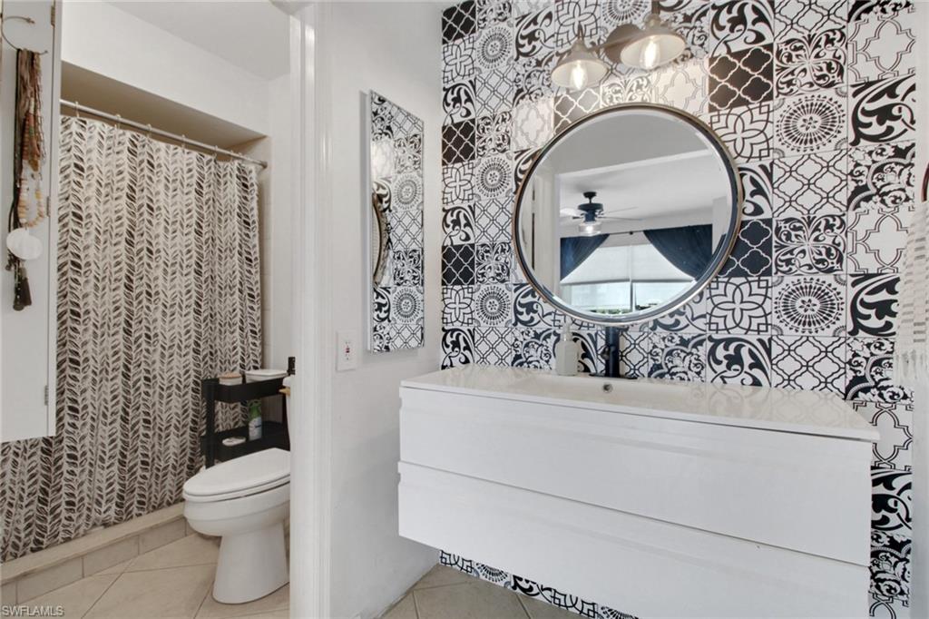 3342 Timberwood Circle Naples, FL 34105 - Photo 18 of 25 a bathroom with a toilet sink and mirror
