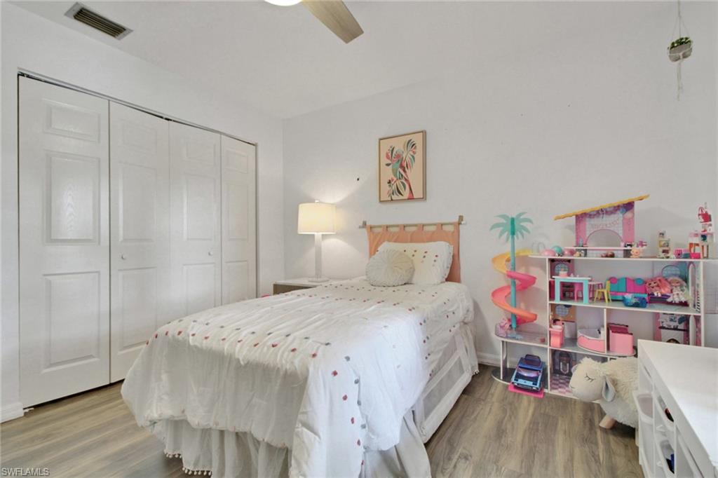 3342 Timberwood Circle Naples, FL 34105 - Photo 21 of 25 a bedroom with a bed and a book shelf