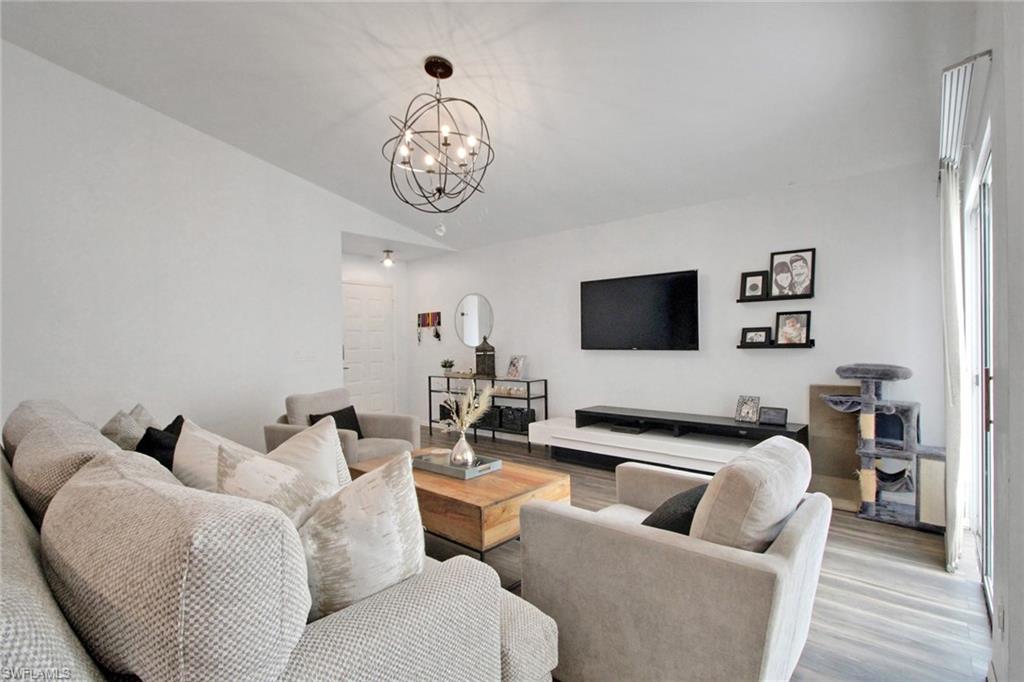 3342 Timberwood Circle Naples, FL 34105 - Photo 6 of 25 a living room with furniture and a flat screen tv