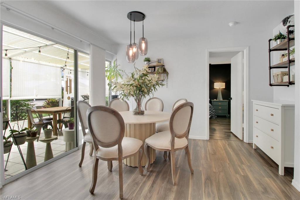 3342 Timberwood Circle Naples, FL 34105 - Photo 9 of 25 a dining room with furniture a chandelier and wooden floor