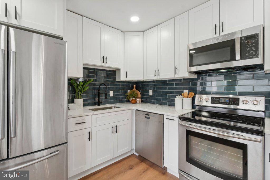 18 Rollwin Road Baltimore, MD 21244 - Photo 13 of 27 a kitchen with stainless steel appliances a stove a microwave and cabinets