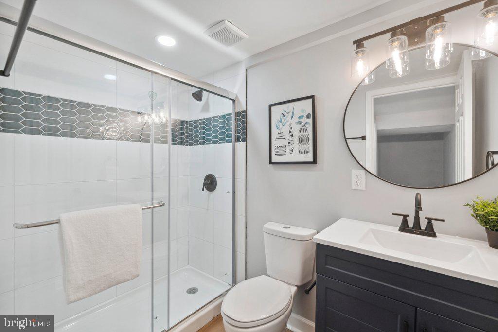 18 Rollwin Road Baltimore, MD 21244 - Photo 23 of 27 a bathroom with a sink a mirror a toilet and a shower