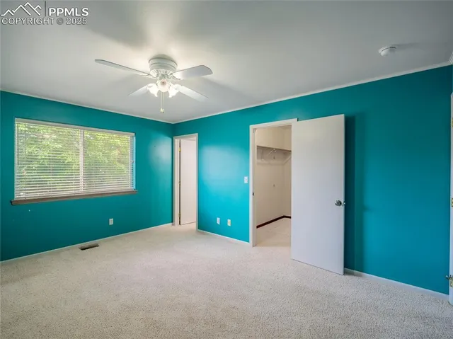 a view of empty room with window and ceiling fan