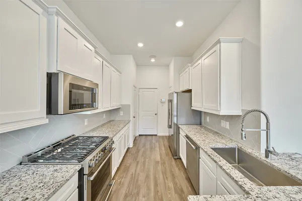 a large kitchen with kitchen island granite countertop a large counter top stainless steel appliances and cabinets
