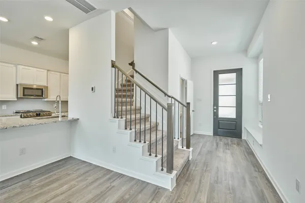 a view of hallway with stairs and wooden floor