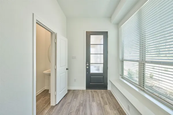 a view of a hallway with wooden floor and a window