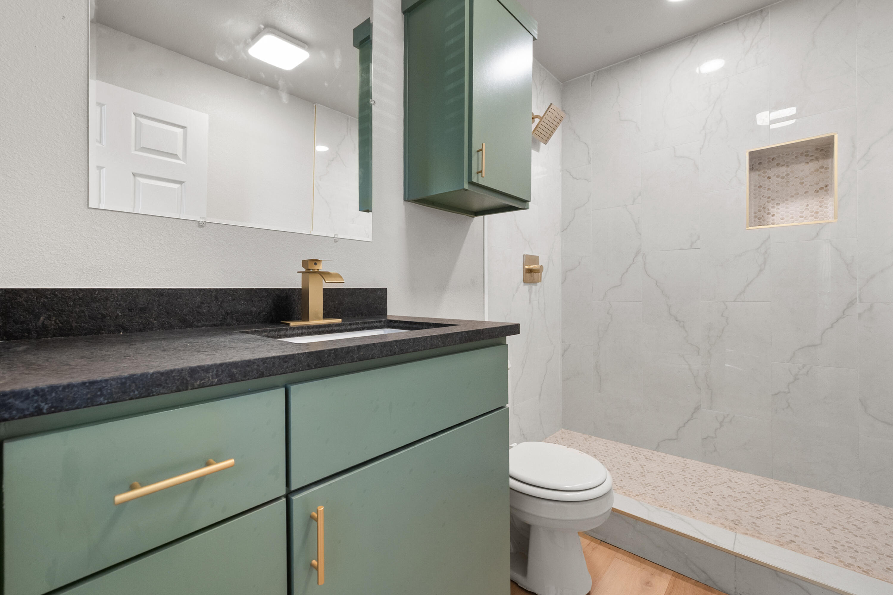2504 53rd Street Lubbock, TX 79413 - Photo 23 of 28 a bathroom with a granite countertop sink a toilet and mirror