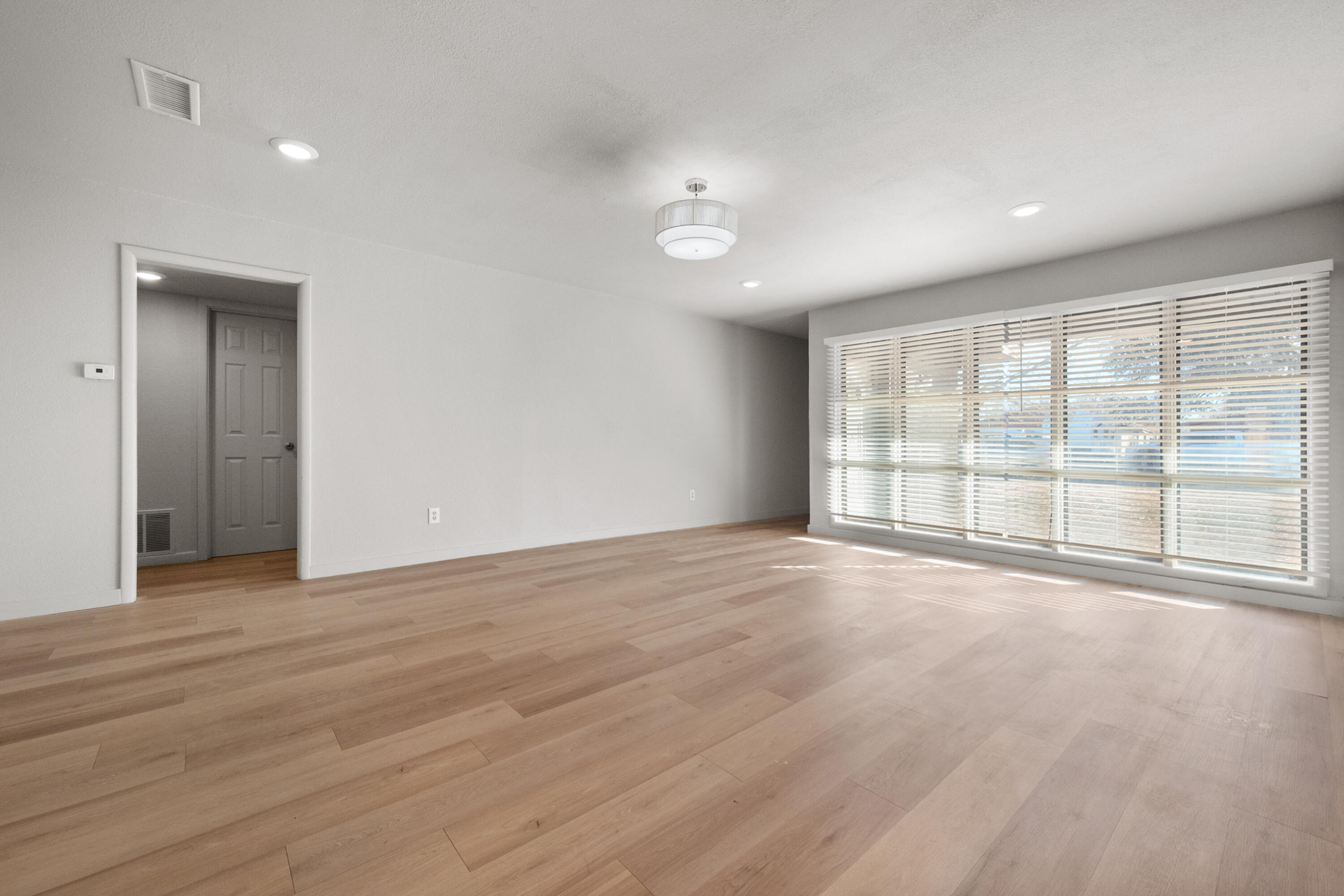 2504 53rd Street Lubbock, TX 79413 - Photo 4 of 28 a view of an empty room with wooden floor and a window