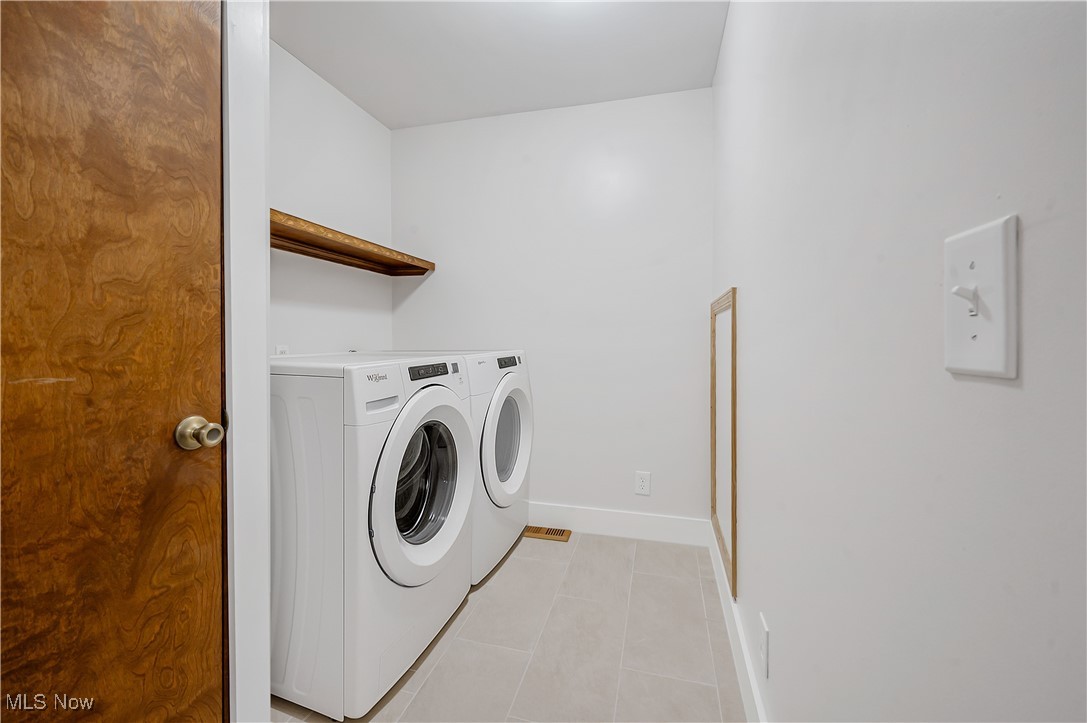 12358 Harmon Road New Springfield, OH 44443 - Photo 34 of 44 Laundry area with light tile patterned floors and washer and clothes dryer