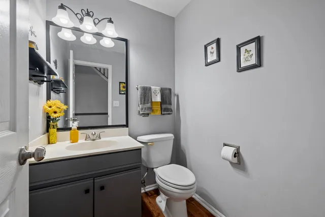 a bathroom with a sink vanity mirror and toilet
