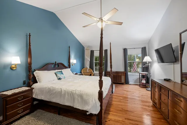 a bedroom with a bed a large window and flat screen tv