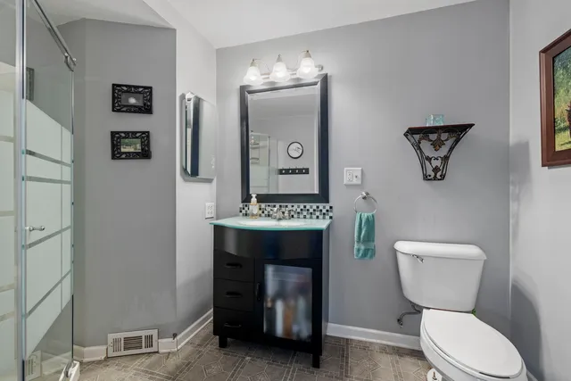 a bathroom with a toilet a sink and mirror