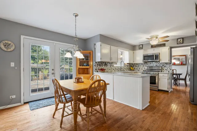 a kitchen with a table chairs refrigerator and cabinets
