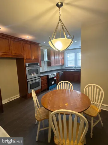 a kitchen with stainless steel appliances wooden floors and wooden cabinets
