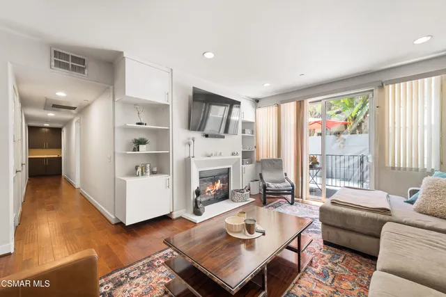a living room with furniture fireplace and a large window