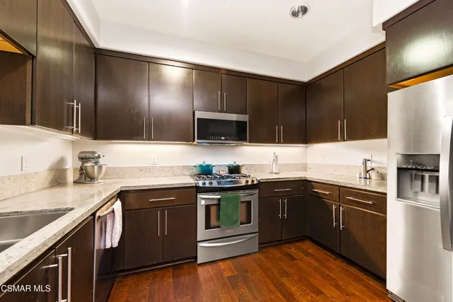 a kitchen with granite countertop stainless steel appliances and sink
