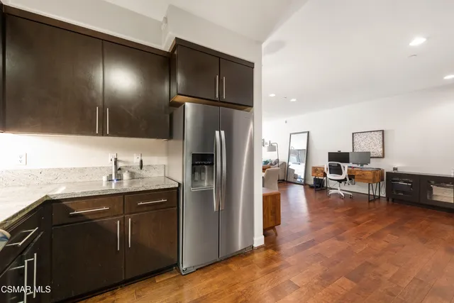a kitchen with stainless steel appliances granite countertop a refrigerator and a sink