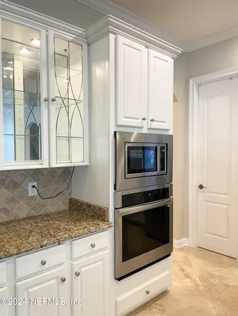 a kitchen with granite countertop a stove a microwave and a sink