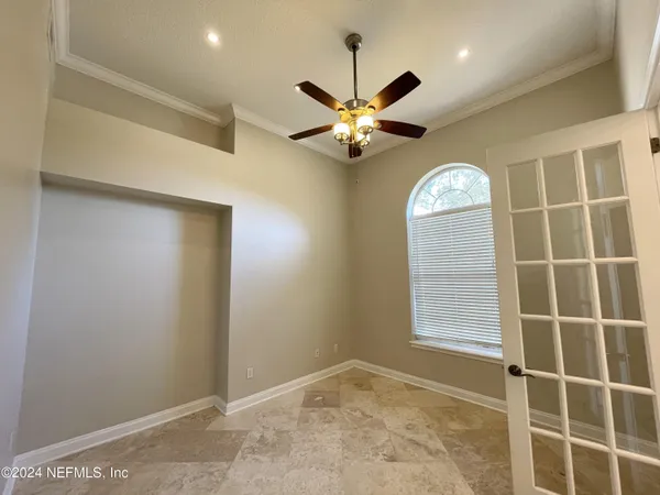 a view of a livingroom with a chandelier fan and a window