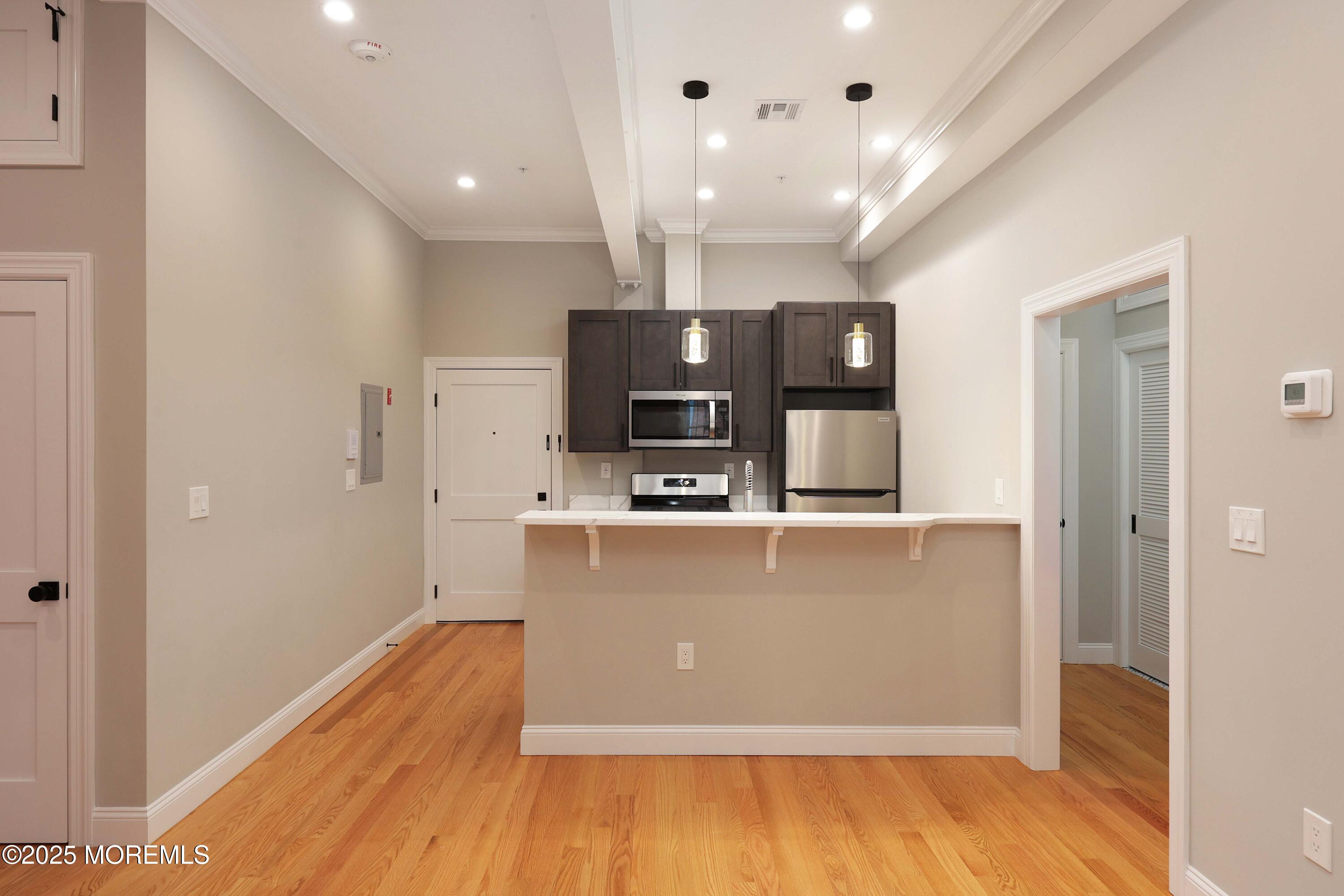 14 East Front Street, Unit 2F Red Bank, NJ 07701 - Photo 1 of 22 a view of kitchen with stainless steel appliances granite countertop a refrigerator a sink dishwasher a stove and white countertops with wooden floor