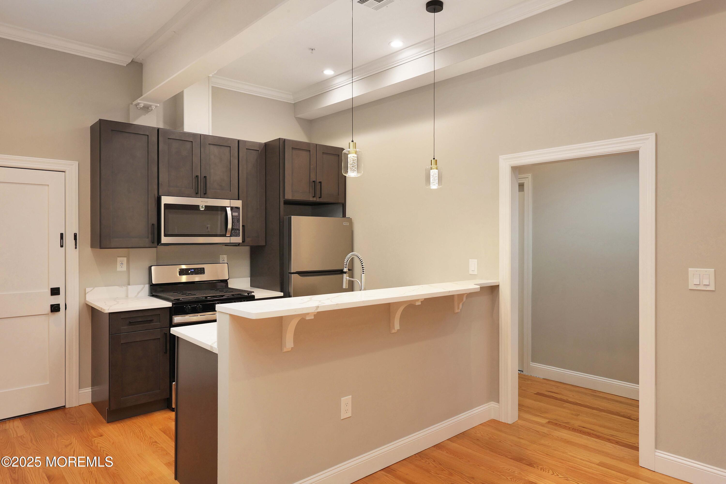 14 East Front Street, Unit 2F Red Bank, NJ 07701 - Photo 2 of 22 a kitchen with stainless steel appliances a refrigerator and a stove