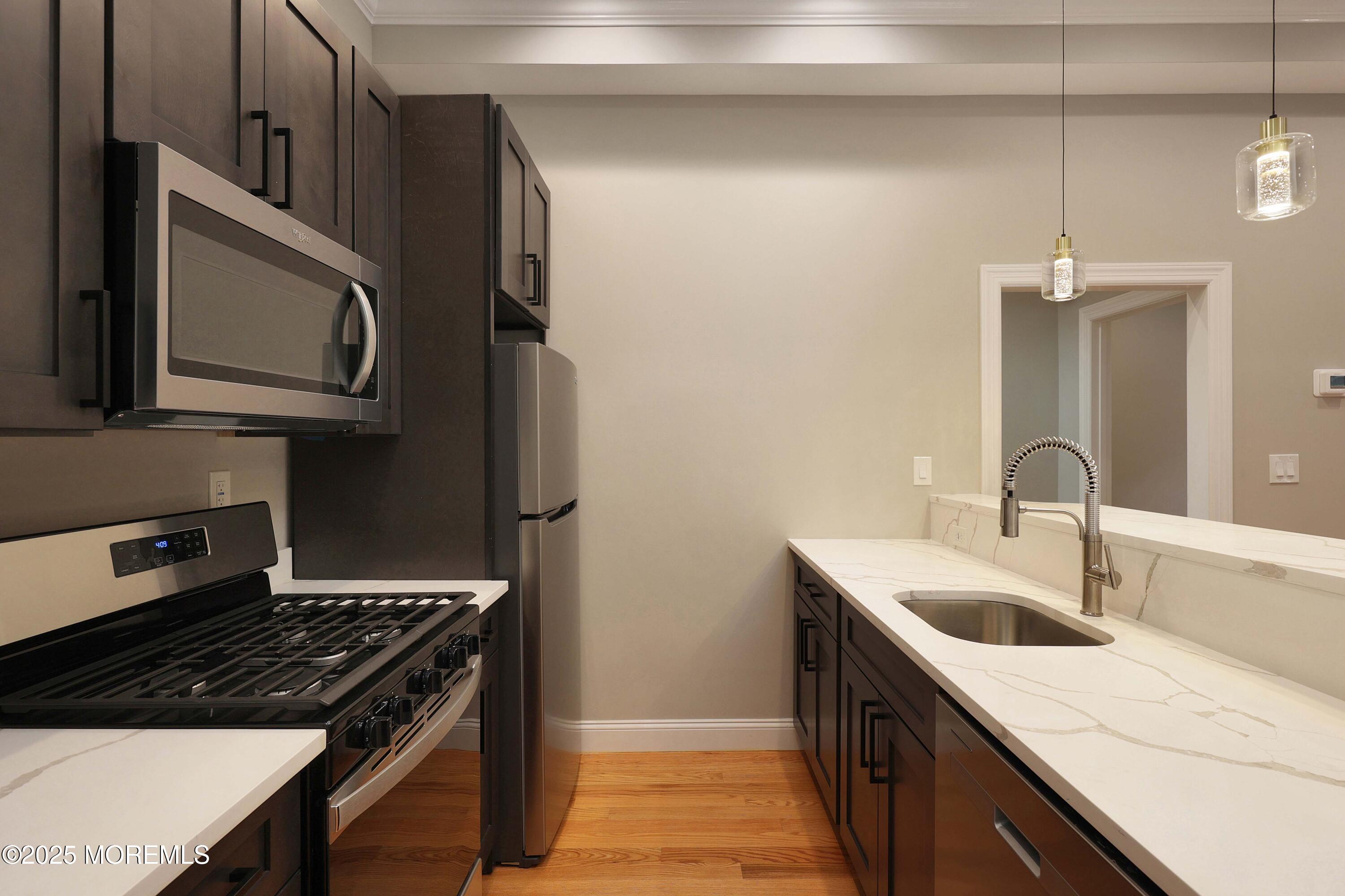 14 East Front Street, Unit 2F Red Bank, NJ 07701 - Photo 5 of 22 a kitchen with stainless steel appliances granite countertop a sink stove and refrigerator