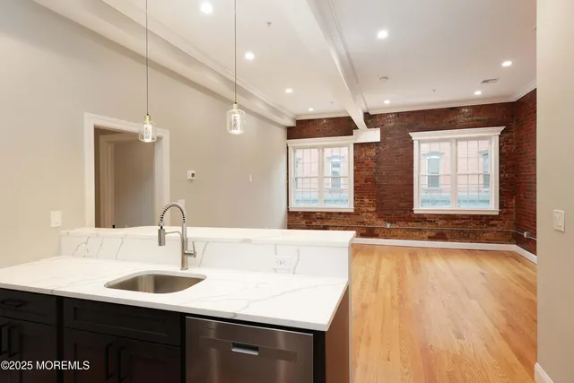 a kitchen with a sink a large window and wooden floor