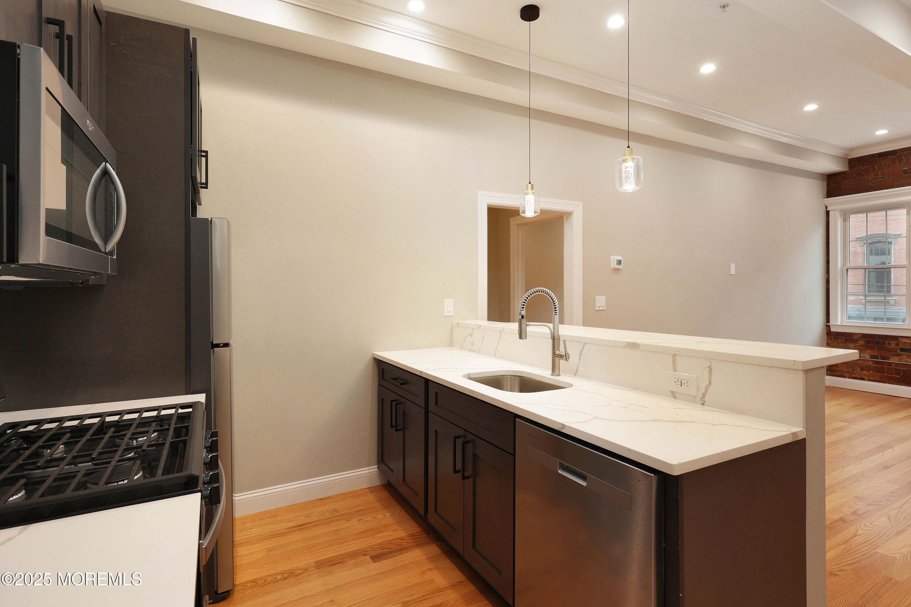 14 East Front Street, Unit 2F Red Bank, NJ 07701 - Photo 8 of 22 a kitchen with a sink and a refrigerator
