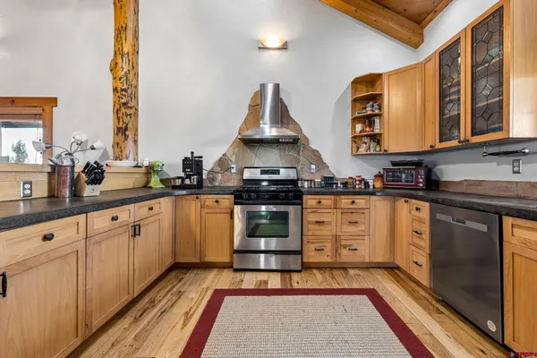 a kitchen with stainless steel appliances a stove and white cabinets