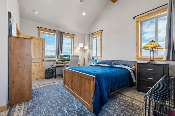 a bedroom with a bed and dresser with mirror