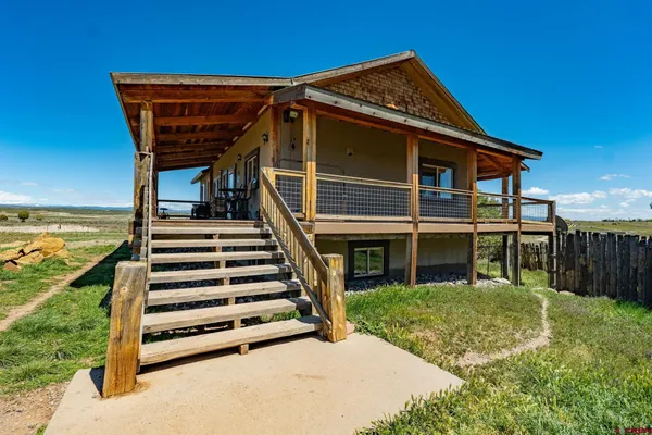 a view of a house with backyard and deck