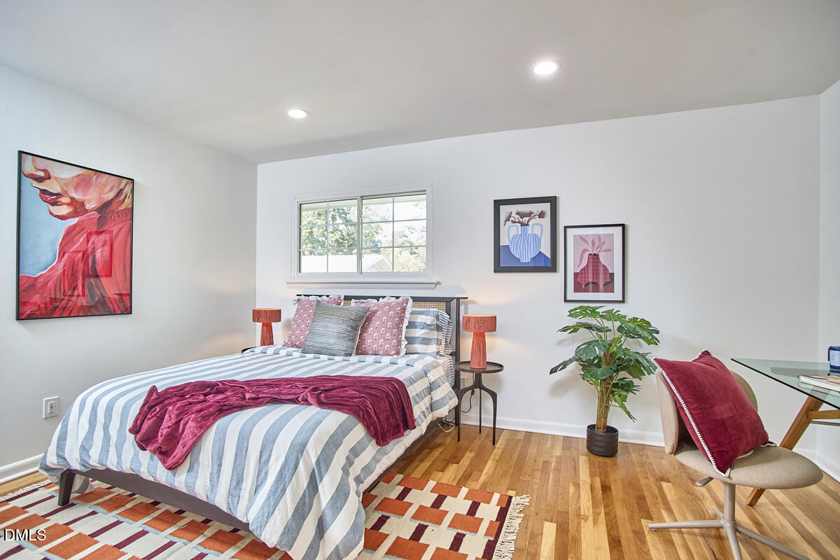 2613 McNeil Street, Unit E Raleigh, NC 27608 - Photo 18 of 28 a bed sitting in a bedroom next to a window