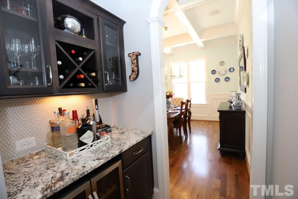 8624 Wapello Lane Raleigh, NC 27613 - Photo 5 of 26 a kitchen with stainless steel appliances granite countertop a stove a dining table and chairs with wooden floor