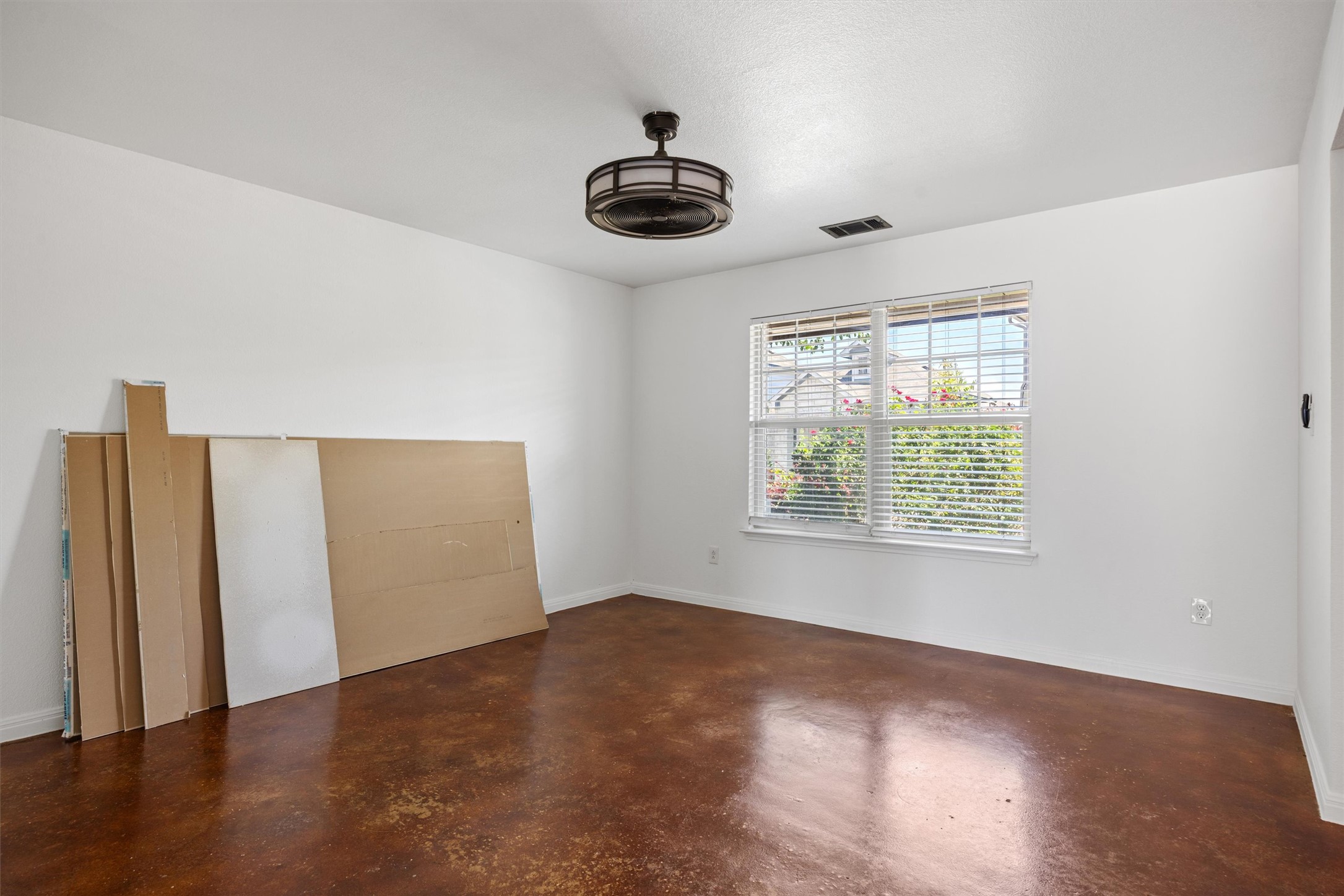 4516 Kind Way, Unit 253 Austin, TX 78725 - Photo 23 of 31 an empty room with wooden floor cabinet and windows
