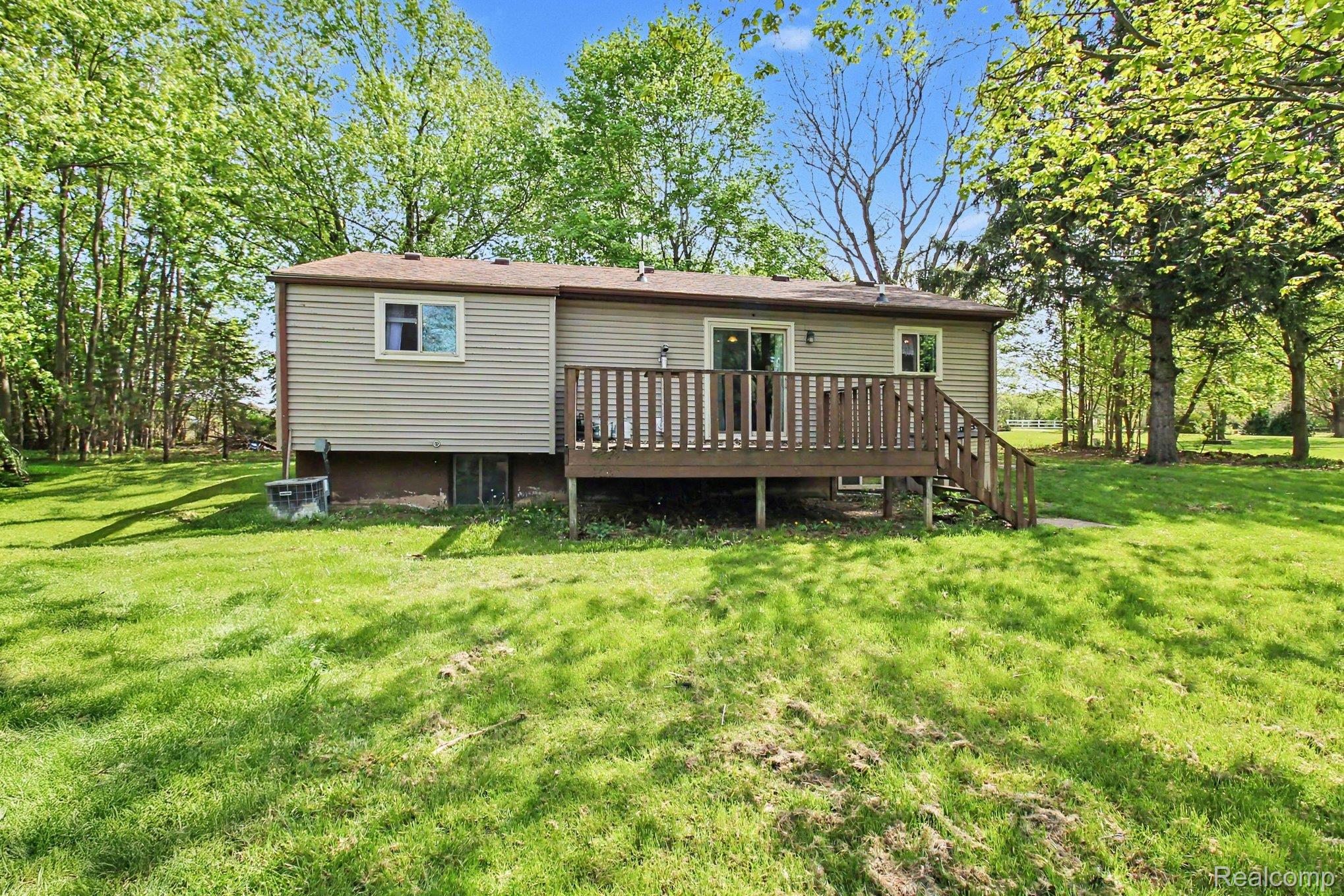 4623 West Lovejoy Road Byron, MI 48418 - Photo 15 of 21 Back of house featuring a lawn and a deck